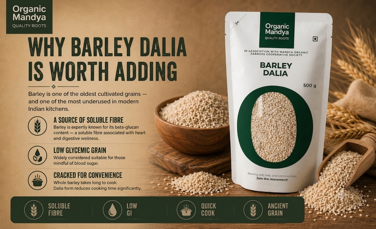 A stand-up pouch of Organic Mandya Barley Dalia is shown on a warm brown promotional background with text callouts about barley benefits and icons for soluble fibre, low GI, quick cook, and ancient grain. The pouch is white with a large dark green circular window and green branding panels.