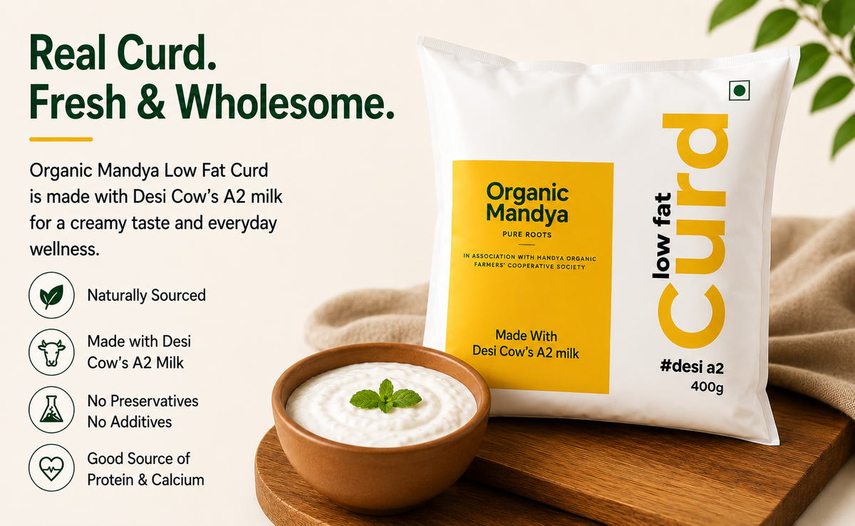 A 400g bag of Organic Mandya Low Fat Curd is displayed next to a small wooden bowl filled with white curd on a wooden board, with marketing text on the left against a warm beige background.
