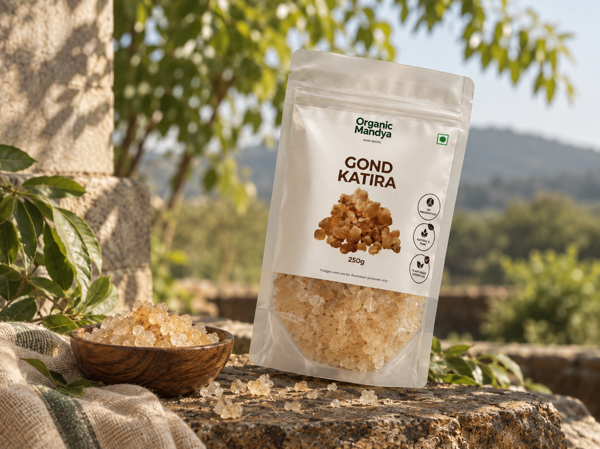 Organic Mandya Gond Katira pouch on a stone ledge beside a wooden bowl of pale tragacanth gum crystals, with a green field and hills behind